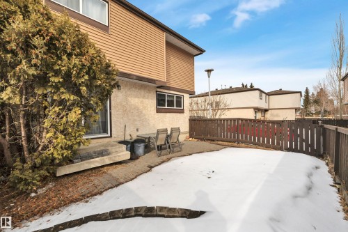 The property features a private fenced yard with a patio area and a mature tree - 585 Knottwood Road W, Edmonton, AB - Outdoor With Exterior