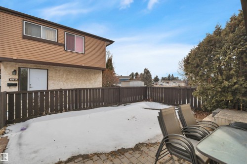 The property features a private fenced yard with a paved patio area - 585 Knottwood Road W, Edmonton, AB - Outdoor