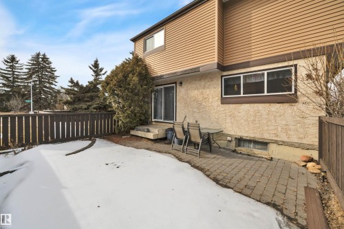 The property features a patio area with brick pavers, a fenced yard, and an exterior with both stucco and siding finishes - 585 Knottwood Road W, Edmonton, AB - Outdoor With Exterior