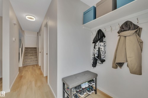 Entryway featuring light-colored flooring, a modern overhead light fixture, and a staircase with carpeted treads - 585 Knottwood Road W, Edmonton, AB - Indoor Photo Showing Other Room