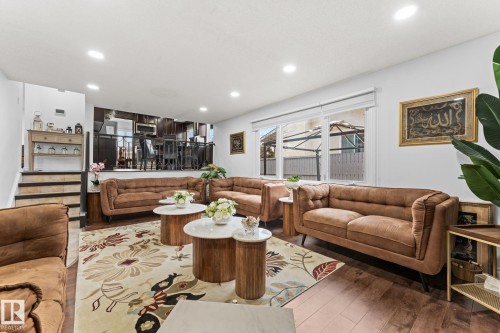Recessed lighting illuminates this living area featuring wood-finish flooring and a partial view of an upper-level space - 16424 106 Street, Edmonton, AB - Indoor Photo Showing Living Room