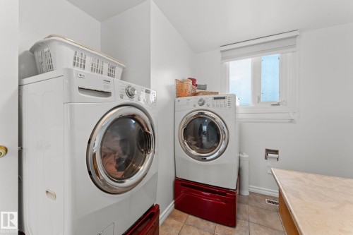 Dedicated laundry area featuring a front-loading washer and dryer set - 16424 106 Street, Edmonton, AB - Indoor Photo Showing Laundry Room