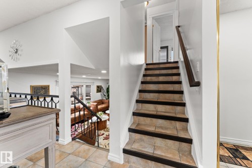 Tile staircase with dark wood-finish handrail - 16424 106 Street, Edmonton, AB - Indoor Photo Showing Other Room