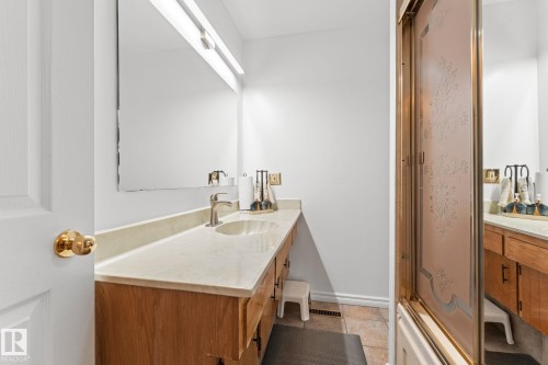 Bathroom vanity with light wood cabinetry, a light-toned countertop, and an integrated sink - 16424 106 Street, Edmonton, AB - Indoor