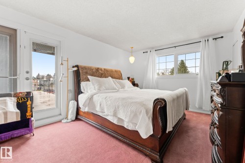 White walls, a single-pane window with grid inserts, and a glass door providing exterior access - 16424 106 Street, Edmonton, AB - Indoor Photo Showing Bedroom