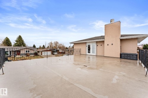 Expansive outdoor deck space featuring concrete surfacing and wrought iron railing - 16424 106 Street, Edmonton, AB - Outdoor With Exterior