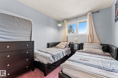 Room featuring light blue walls, textured ceiling, and pink carpet flooring - 16424 106 Street, Edmonton, AB - Indoor Photo Showing Bedroom