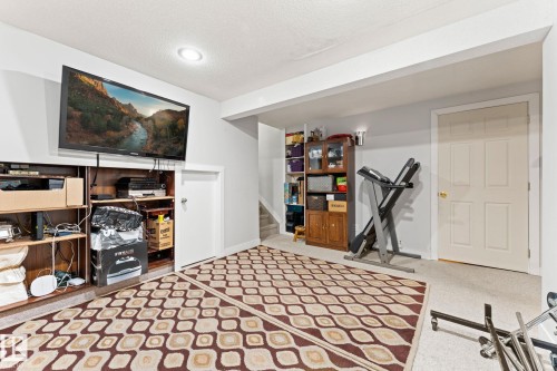 Lower-level finished space featuring overhead recessed lighting and a neutral color palette - 16424 106 Street, Edmonton, AB - Indoor Photo Showing Other Room