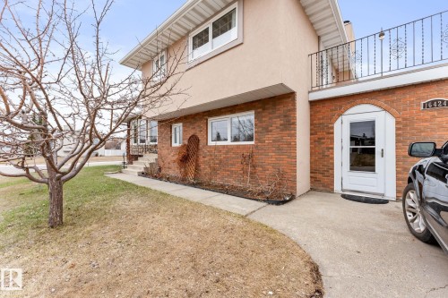 Brick facade with arched doorway entry and concrete walkway - 16424 106 Street, Edmonton, AB - Outdoor
