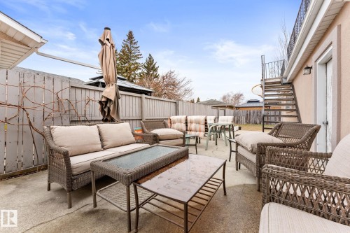 Expansive concrete patio area with a spiral staircase providing exterior access to an upper-level balcony - 16424 106 Street, Edmonton, AB - Outdoor With Deck Patio Veranda