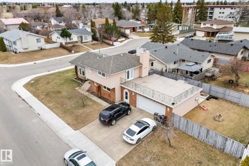 Split-level residence featuring a two-car garage with a rooftop patio, an attached outdoor patio, and a fenced backyard - 16424 106 Street, Edmonton, AB - Outdoor