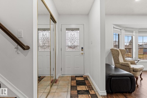 Entryway featuring a decorative glass panel door, mirrored sliding closet doors, and tile flooring - 16424 106 Street, Edmonton, AB - Indoor Photo Showing Other Room