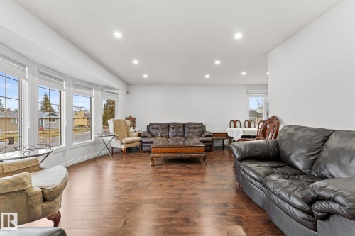 Spacious living area featuring wood-finish flooring, recessed lighting, and a bay window configuration - 16424 106 Street, Edmonton, AB - Indoor Photo Showing Living Room