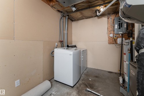 Utility area with a concrete floor and exposed overhead pipes - 3 9703 174 Street, Edmonton, AB - Indoor Photo Showing Laundry Room