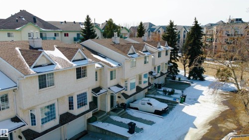 This property features a multi-level design with light-colored exterior siding and prominent dormer windows - 3 9703 174 Street, Edmonton, AB - Outdoor