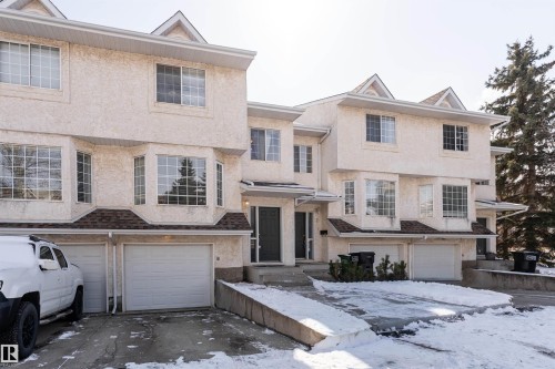 The property features bay windows on the main level, large upper-level windows, and a multi-car garage with individual doors - 3 9703 174 Street, Edmonton, AB - Outdoor With Facade