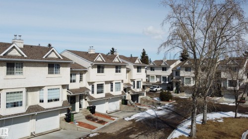 The property is a multi-story home featuring a light-colored exterior and a brown roof - 3 9703 174 Street, Edmonton, AB - Outdoor With Facade