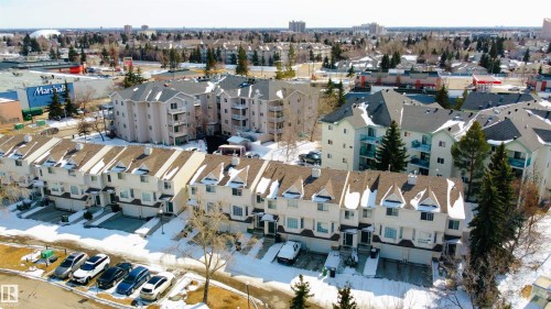 Aerial view of a community featuring a row of townhouses with attached garages and multi-story apartment buildings - 3 9703 174 Street, Edmonton, AB - Outdoor With View