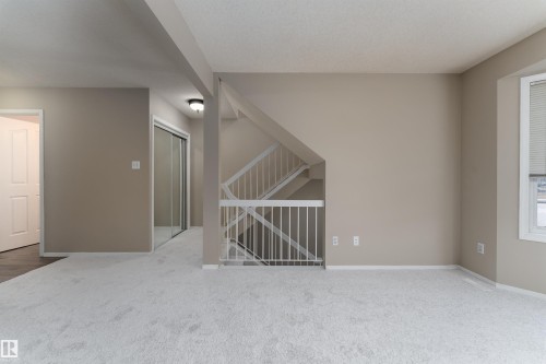 Spacious room featuring light-colored carpet, neutral-toned walls, and a window with blinds - 3 9703 174 Street, Edmonton, AB - Indoor Photo Showing Other Room
