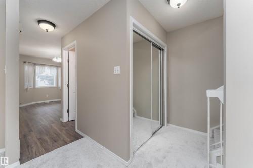 This area features light grey walls, light-colored carpeting, and a mirrored sliding closet door - 3 9703 174 Street, Edmonton, AB - Indoor