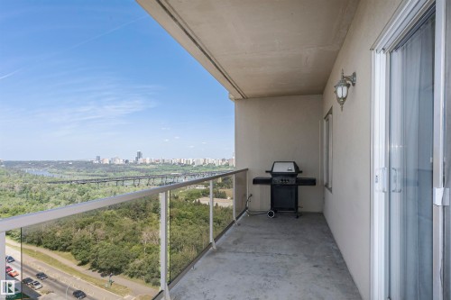 Spacious balcony featuring glass and aluminum railing, concrete flooring, and a wall-mounted exterior light fixture - 1701 10649 Saskatchewan Drive, Edmonton, AB - Outdoor With View With Exterior