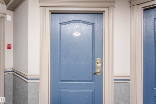 Entry door featuring a decorative panel design and brass hardware - 1701 10649 Saskatchewan Drive, Edmonton, AB - Outdoor With Exterior