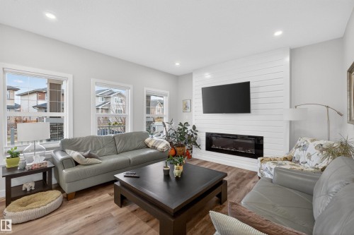 Living area featuring wood-finish flooring, recessed lighting, and white walls - 53 Wingate Way, Fort Saskatchewan, AB - Indoor Photo Showing Living Room With Fireplace
