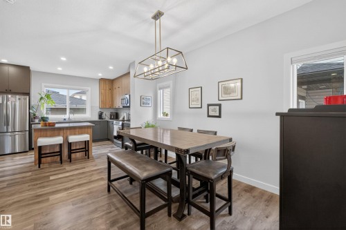 Open-concept dining area and kitchen featuring wood-finish flooring - 53 Wingate Way, Fort Saskatchewan, AB - Indoor Photo Showing Dining Room