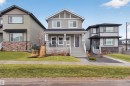 Two-story residence featuring a covered front porch with white railings, a blue front door, and a stone facade foundation - 53 Wingate Way, Fort Saskatchewan, AB  - Outdoor With Facade 