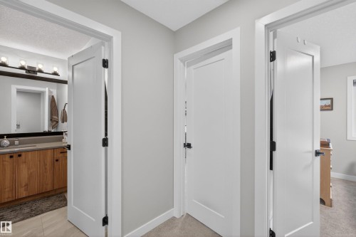 Hallway featuring light gray walls, white trim, and a neutral carpet - 53 Wingate Way, Fort Saskatchewan, AB - Indoor Photo Showing Other Room