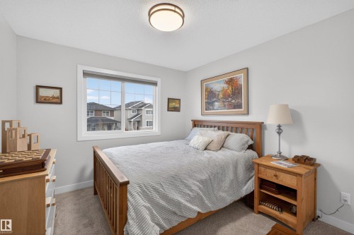 Bedroom featuring light gray walls, carpet flooring, and a large window with white trim - 53 Wingate Way, Fort Saskatchewan, AB - Indoor Photo Showing Bedroom