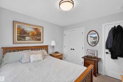 Neutral painted walls with a textured ceiling and a contemporary flush-mount light fixture - 53 Wingate Way, Fort Saskatchewan, AB - Indoor Photo Showing Bedroom