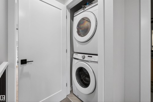Convenient laundry closet with a stacked front-load washer and dryer - 53 Wingate Way, Fort Saskatchewan, AB - Indoor Photo Showing Laundry Room