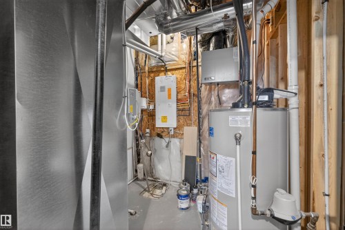 Utility area with a water heater, exposed wooden wall studs, and various visible piping - 53 Wingate Way, Fort Saskatchewan, AB - Indoor Photo Showing Basement