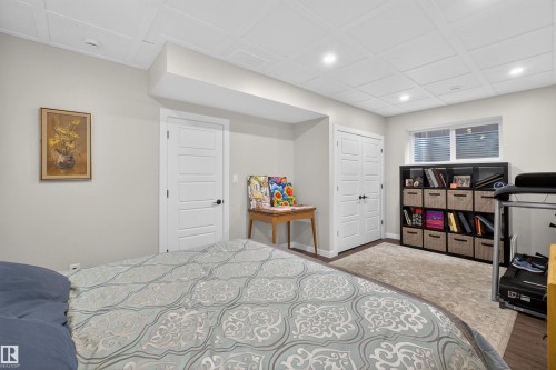 Recessed lighting illuminates this room, featuring light gray walls, a drop ceiling, and wood-finish flooring partially covered by an area rug - 53 Wingate Way, Fort Saskatchewan, AB - Indoor Photo Showing Bedroom