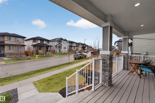 Covered front porch with composite decking, recessed lighting, and stone-clad columns - 53 Wingate Way, Fort Saskatchewan, AB - Outdoor With Deck Patio Veranda