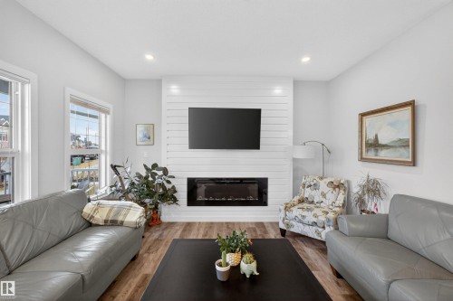 Living area featuring a shiplap accent wall with an integrated electric fireplace - 53 Wingate Way, Fort Saskatchewan, AB - Indoor Photo Showing Living Room With Fireplace