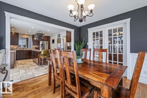 Dining area featuring wood-finish flooring and a decorative chandelier - 6003 176 Street, Edmonton, AB - Indoor Photo Showing Dining Room