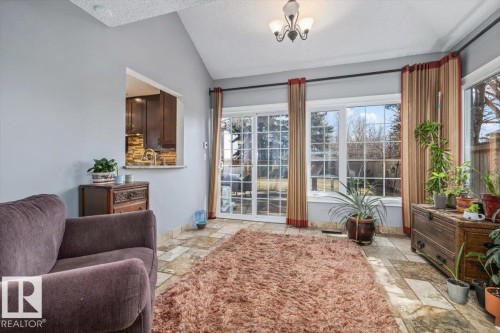 Spacious sunroom featuring vaulted ceilings, light-toned tiled flooring, and multiple paned windows - 6003 176 Street, Edmonton, AB - Indoor Photo Showing Living Room