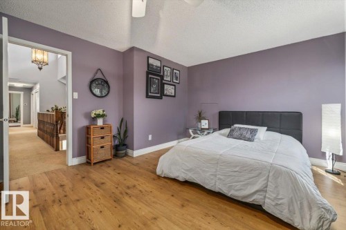 Room featuring light wood-finish flooring, white baseboards, and a ceiling fan - 6003 176 Street, Edmonton, AB - Indoor Photo Showing Bedroom