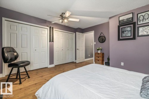 Spacious room featuring wood-finish flooring and two sets of bi-fold closet doors - 6003 176 Street, Edmonton, AB - Indoor Photo Showing Bedroom