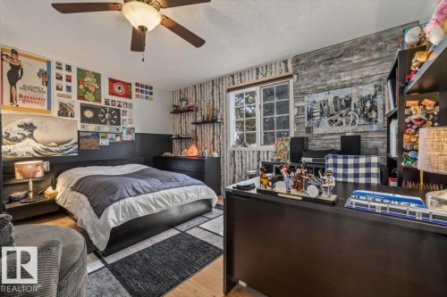 Spacious bedroom featuring wood-finish flooring and a ceiling fan - 6003 176 Street, Edmonton, AB - Indoor Photo Showing Bedroom