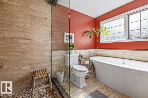 Freestanding soaking tub with chrome fixtures, set against a vibrant wall color - 6003 176 Street, Edmonton, AB - Indoor Photo Showing Bathroom