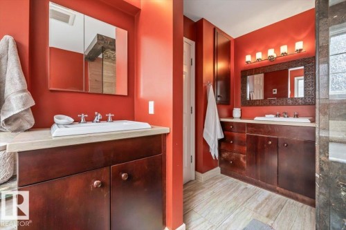 Bathroom featuring dual vanity areas with wood cabinetry and light-toned countertops - 6003 176 Street, Edmonton, AB - Indoor Photo Showing Bathroom