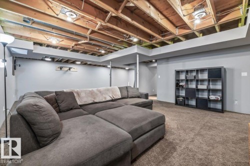 Lower level featuring exposed wood joists, gray painted walls, and brown carpet flooring - 6003 176 Street, Edmonton, AB - Indoor Photo Showing Basement
