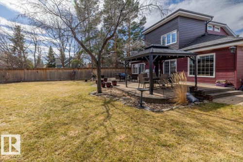 Expansive backyard featuring a large paved patio, a built-in pergola, mature trees, and a privacy fence - 6003 176 Street, Edmonton, AB - Outdoor With Deck Patio Veranda