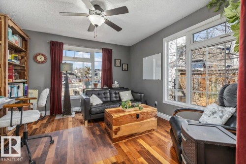 Spacious room featuring wood-finish flooring and a ceiling fan - 6003 176 Street, Edmonton, AB - Indoor