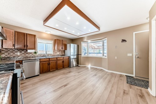 The kitchen features light wood flooring, wood cabinetry, and stainless steel appliances - 4224 30 Street, Edmonton, AB - Indoor Photo Showing Kitchen