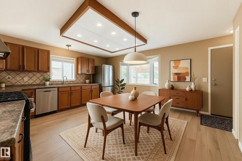 The kitchen and dining area features wood flooring, a decorative light fixture, and a built-in kitchen with wood cabinetry, a tile backsplash, and stainless steel appliances - 4224 30 Street, Edmonton, AB - Indoor