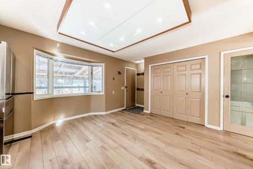 This inviting room features light-toned wood flooring, a decorative ceiling fixture with recessed lighting, and a bay window providing natural light - 4224 30 Street, Edmonton, AB - Indoor Photo Showing Other Room
